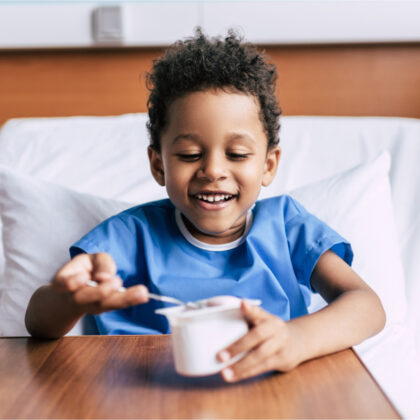 Boy in hospital with bowl of yoghurt